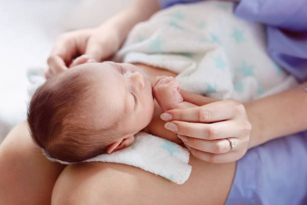 istock Newborn baby in mothers lap 957068476