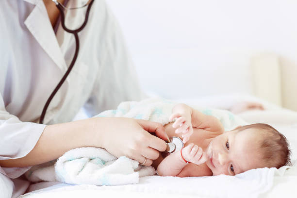ärztin untersucht säugling mit stethoskop - kinderarzt stock-fotos und bilder