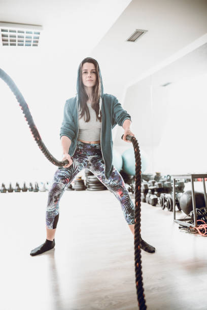 istock Athlete Female Make Battle Rope Exercise in the Gym 957073694