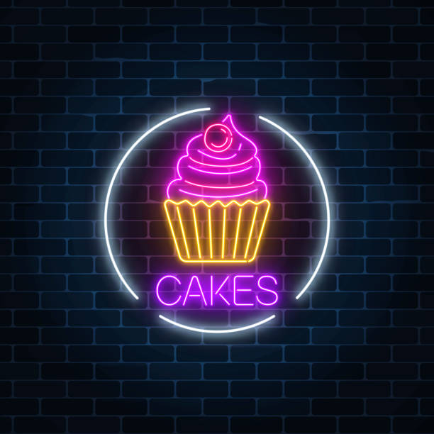 istock Neon glowing sign of cake with cream and cherry in circle frame on a dark brick wall background. 957087220
