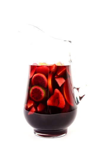 Brightly lit pitcher of sangria; floating fruit in red wine, a great summer beverage; soft shadow at base of pitcher; copy space 