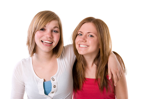 Low key portrait of two young women posing for the camera in the studio. Horizontally.