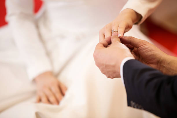 istock Wedding rings.He Put the Wedding Ring on Her.Close up Groom Put the Ring on bride. 957090220