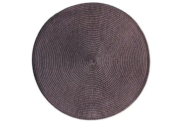Round woven straw mat isolated against white background