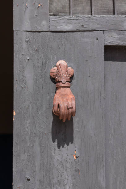 istock rusty door knocker on rough wooden door 957096138