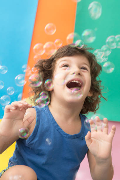 istock Happy Baby boy playing with soap bubbles 957096854