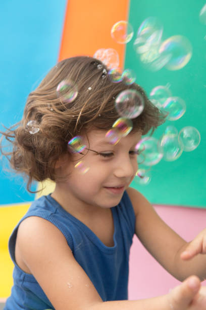 istock Happy Baby boy playing with soap bubbles 957096886