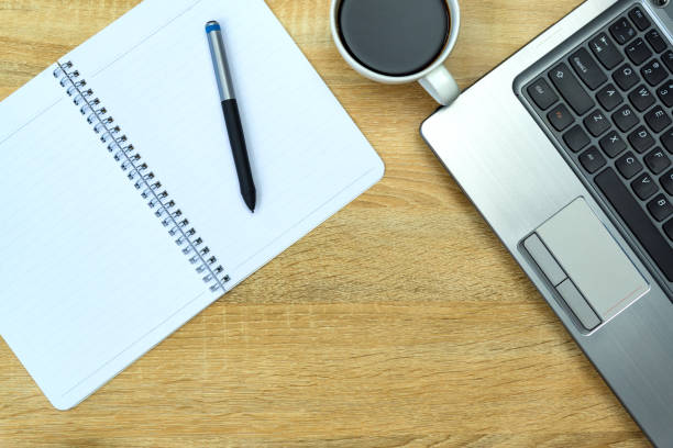 istock Laptop computer or notebook, note and cup of coffee on working table with copy space top view. 957100044