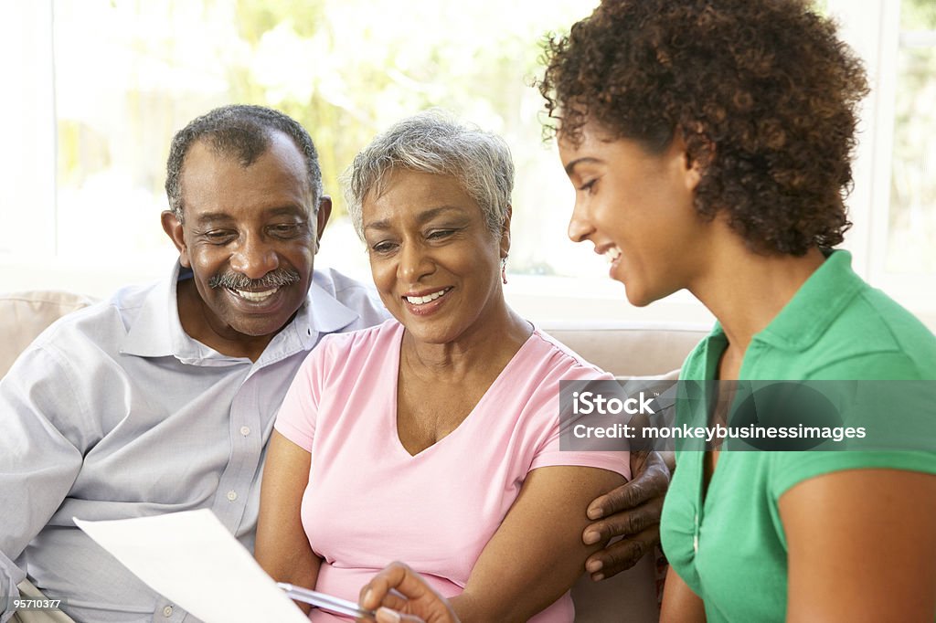 Senior Couple Talking To Financial Advisor At Home  Senior Adult Stock Photo