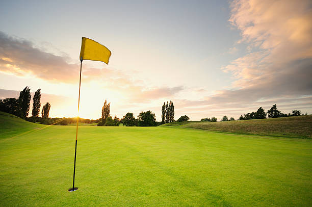 puesta de sol sobre el 18 - golf flag fotografías e imágenes de stock