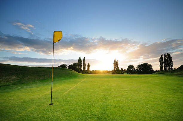 puesta de sol sobre el 18 - golf flag fotografías e imágenes de stock