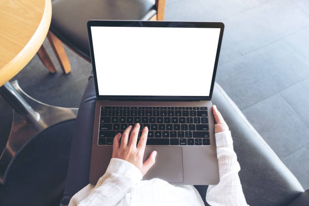 istock Top view mockup image of woman's hands using and typing on laptop with blank white desktop screen while sitting in cafe 957116718