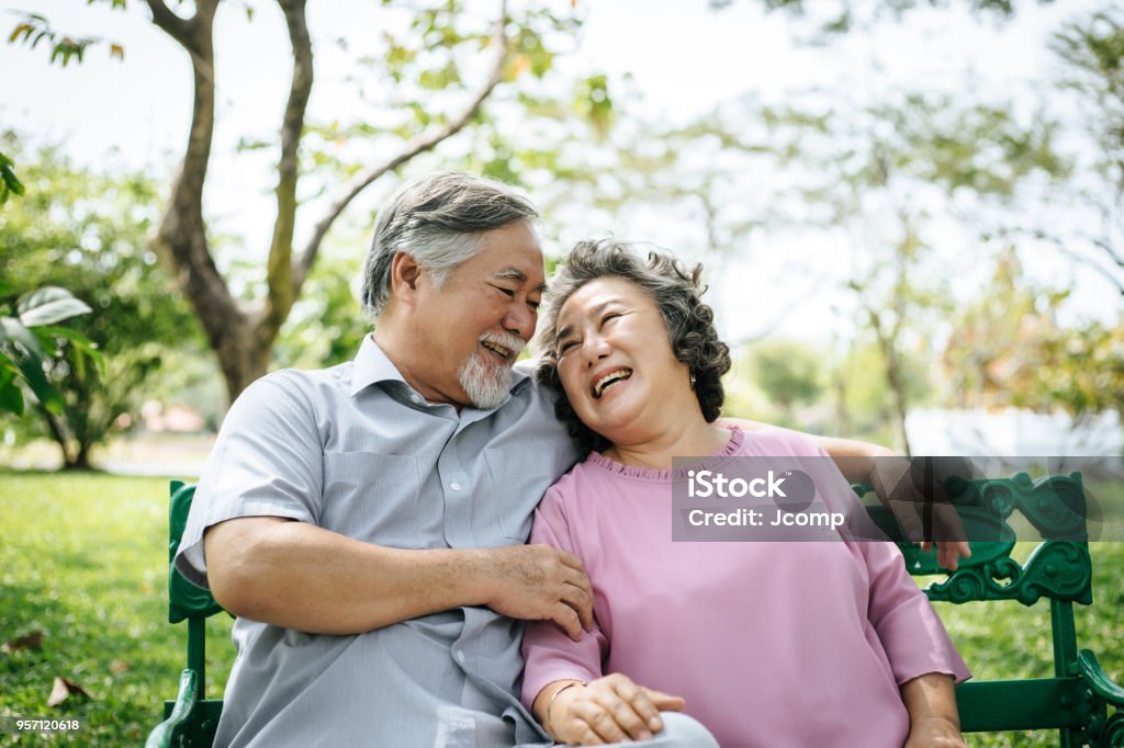 healthy senior couple relaxing  seats on the bench in the park Senior Adult Stock Photo