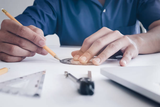 istock architect design concept, Engineering hand holding pencil design building on blueprint with use laptop computer, rulers and dividers of drawing in job site. 957121620