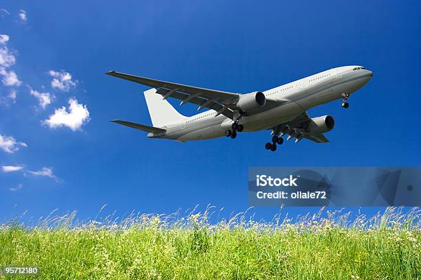 Foto de Avião Voando Em Um Céu Azul E Verde Grama e mais fotos de stock de Aeroporto - Aeroporto, Asa de aeronave, Aterrissar