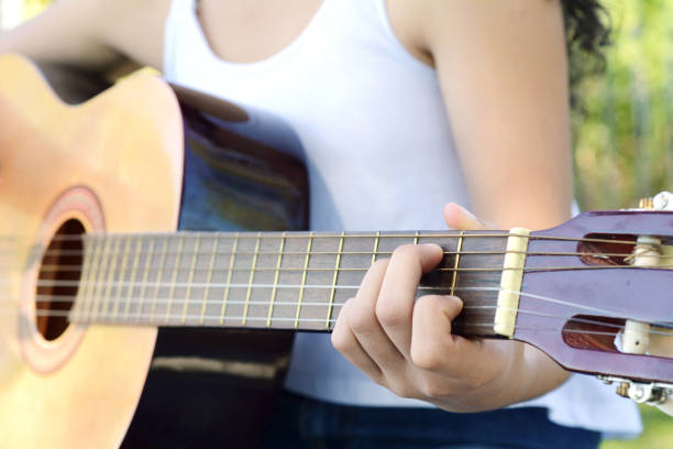 istock Woman playing guitar at the park. 957124204