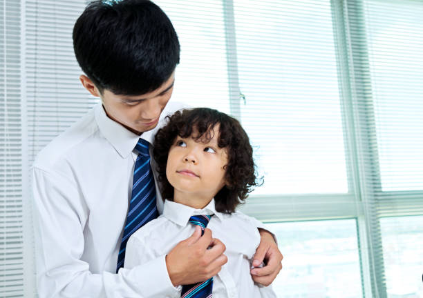 istock Father helping his son to adjusting the tie 957125166