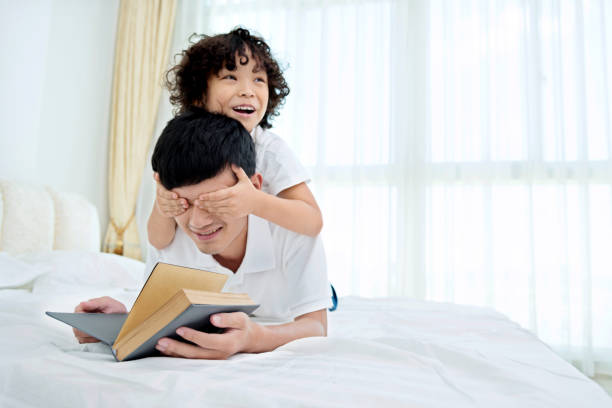 istock Little boy covering his father's eyes 957126088