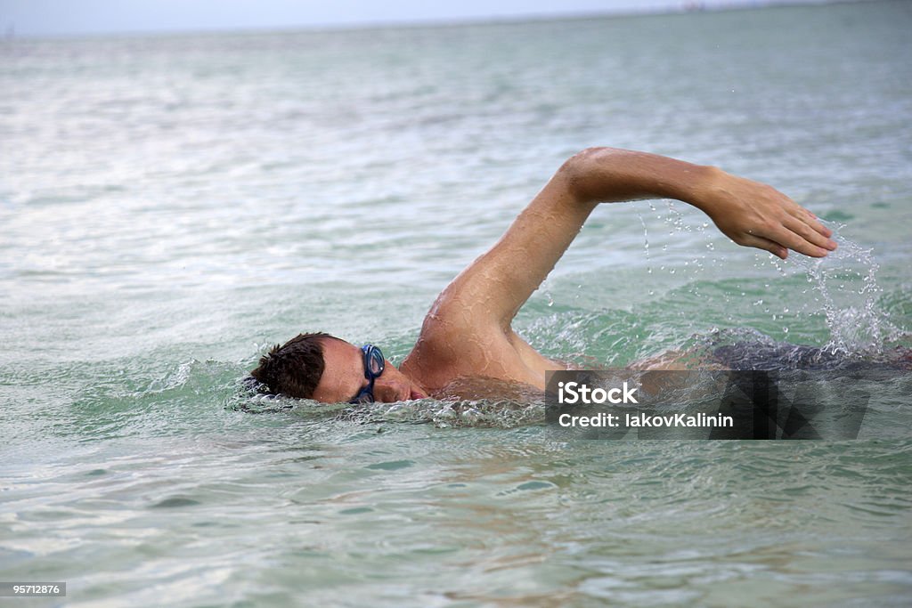 Jeune homme swiming dans l'eau des océans - Photo de Adulte libre de droits