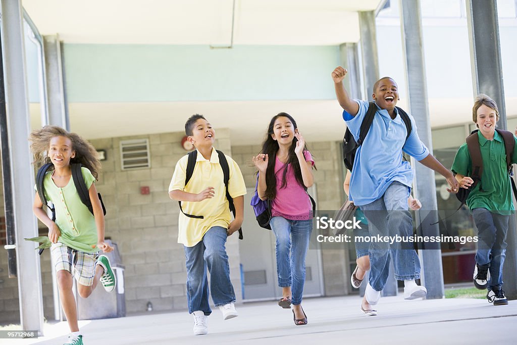 Alunni di scuola elementare in esecuzione all'esterno - Foto stock royalty-free di Bambino