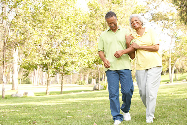 sênior casal andando no parque - couple mature adult action walking - fotografias e filmes do acervo