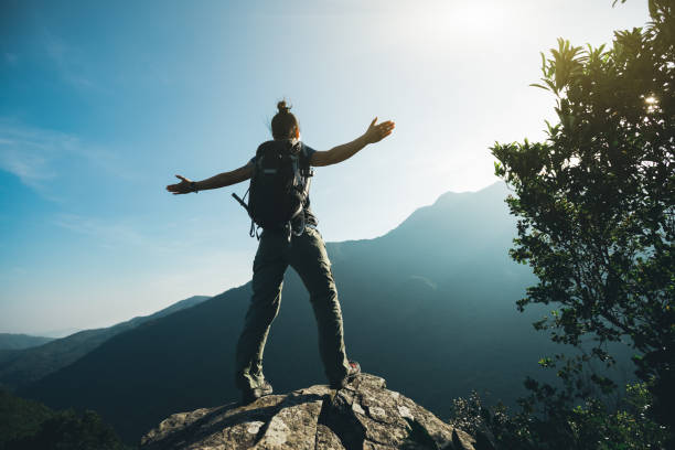 istock successful hiker with arms outstretched on sunrise mountain top 957130194