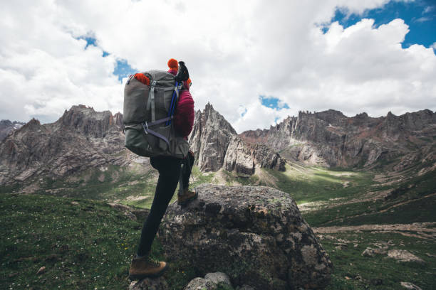 istock Woman hiker with backpack hiking on high altitude mountain top 957130284