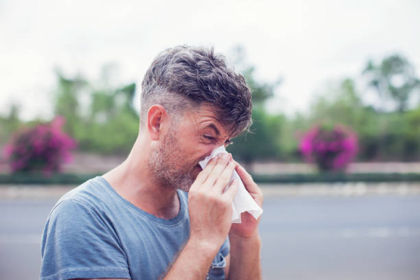 istock Man sneezing in a tissue outdoors. Pollen allergy, Springtime. 957131242