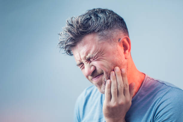 maux de dents, la médecine, la notion de santé, problème de dents, jeune homme souffrant de douleurs dentaires, caries - rage de dents photos et images de collection