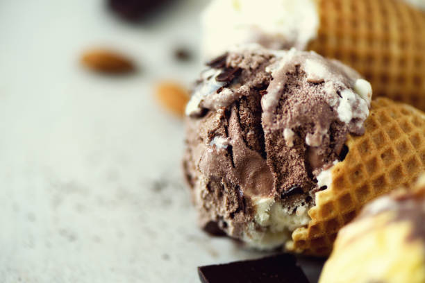 istock Chocolate and coffee ice cream in waffle cone with coffee beans on grey stone background. Summer food concept, copy space. Healthy gluten free ice-cream. Top view 957131554