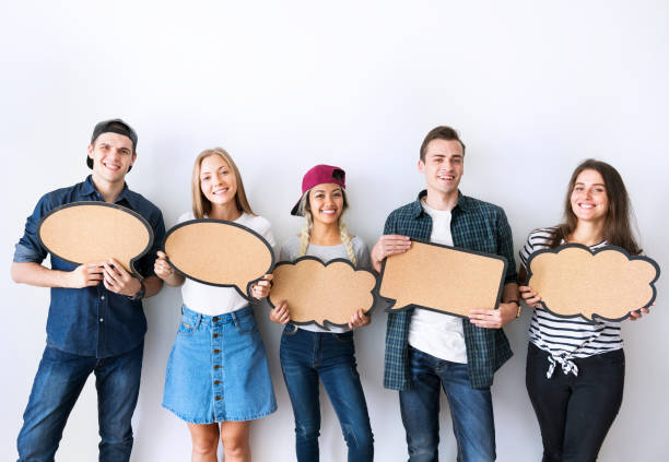 istock Happy young adults holding up copy space placard thought bubbles 957133924