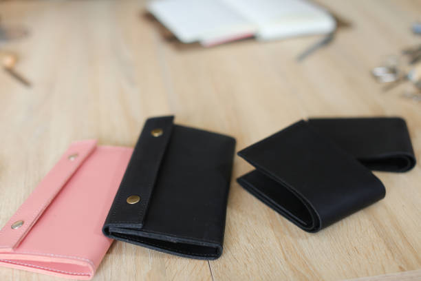 istock Black and pink cute handmade leather wallets and notebook lying on table 957134540