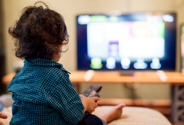 istock Young Indian boy watching television 957135084