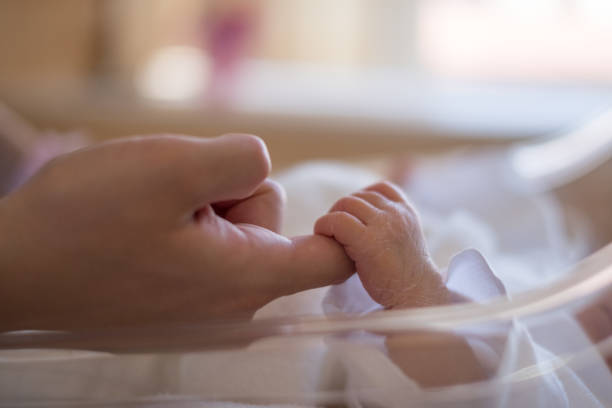 istock newborn baby holding mother's hand 957136314