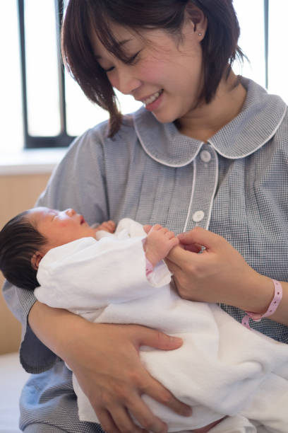 istock newborn baby in mother's arms 957136810