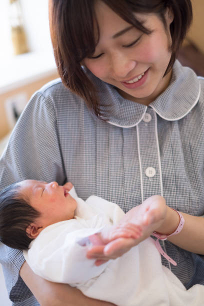 istock newborn baby in mother's arms 957136844