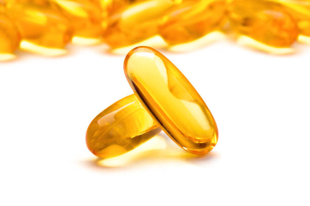 istock Two capsules Omega 3 isolated on white background 957139282