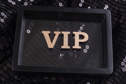 VIP is written in abstract letters in a black frame. Black luxurious sparkling background