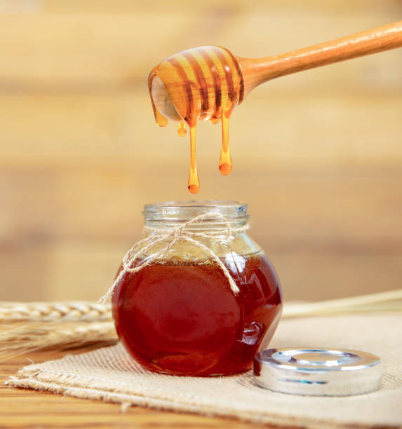 istock honey and honey comb with wooden stick 957144170