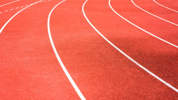 istock red running track on athletic stadium background texture 957145422