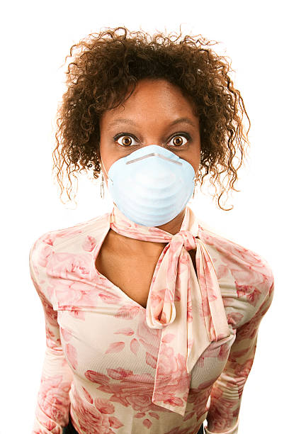 Around the world, health care workers are on the frontlines of the COVID-19 pandemic, providing essential services to those already infected or at high risk. The novel coronavirus has shined a light on dangerous working conditions and low pay. Here, a health care aide demonstrates proper handling of a surgical mask—critical personal proective equipment for those who work in hospitals and long-term care facilities.