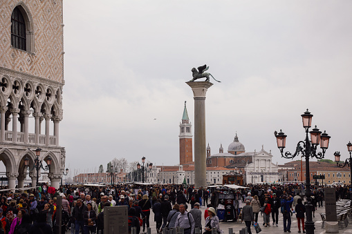 View from the waterfront Riva degli Schiavoni at the distant Tower of San Marco with Doge Palace on a hazy winter day, Venice, Veneto, Italy