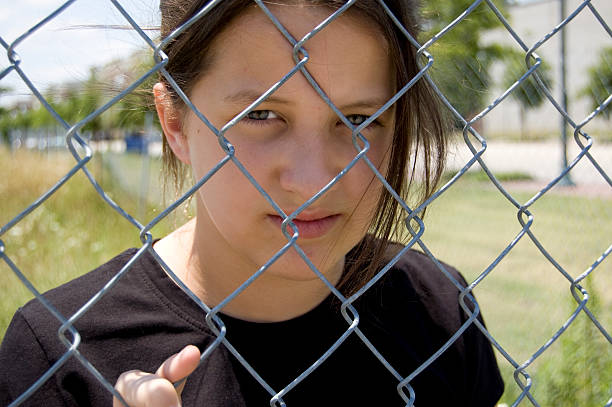 istock Young girl through fence 95715394