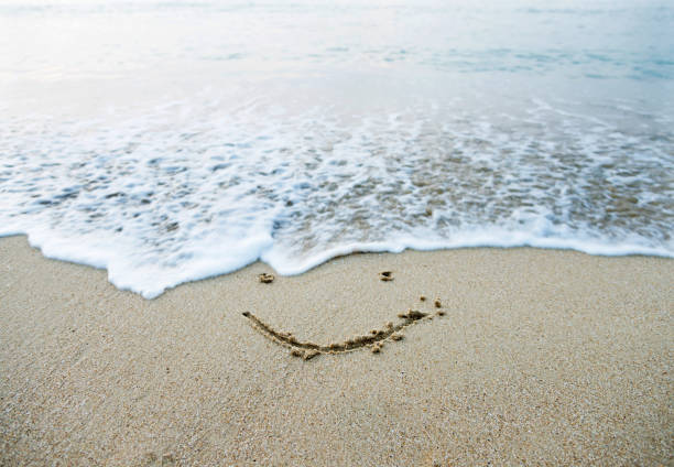 istock Single smile face on the sand of a beach 957155538