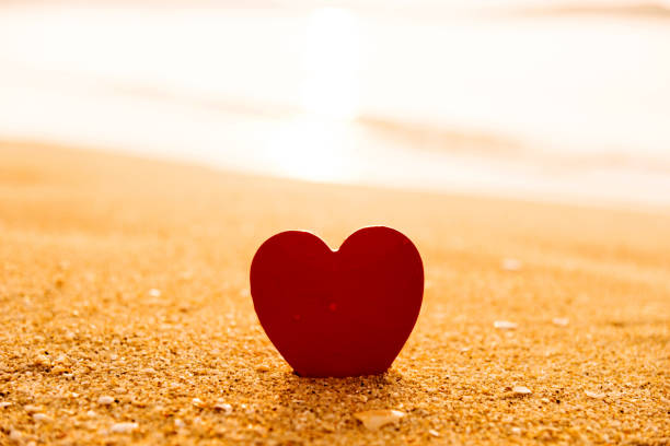istock Red heart shape on the golden beach 957155806
