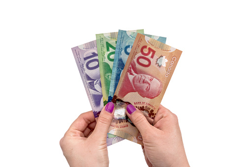 Canadian dollar on female hand isolated on white