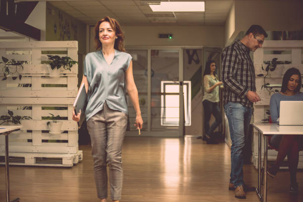 istock Happy businesswoman walking through office 957162696