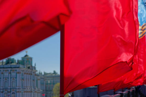 istock Red cloth or silk flag waving at wind. Holiday background. 957162968