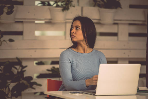 Eavesdropping coworker Young woman is looking and listening to her coworkers in the office. eavesdropping stock pictures, royalty-free photos & images