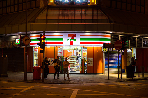 24 hours convenience store 7-11 or 7-Eleven opening all night make bright night road and safety in Hong Kong. 24 November 2017.